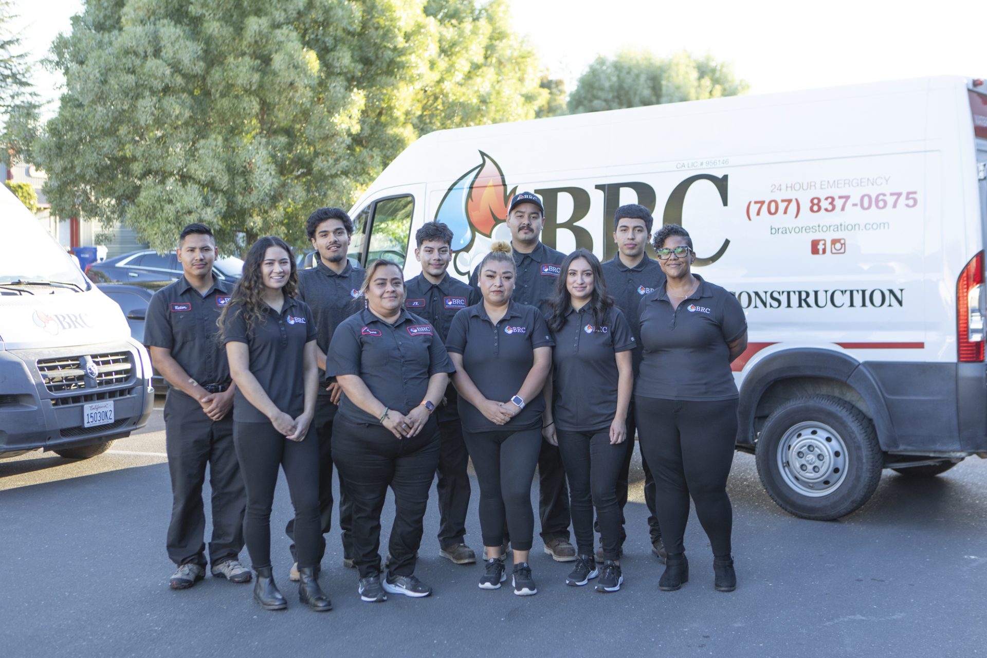 Bravo Restoration's team of mold remediation experts and fire damage remediation experts are seen standing in front of their service van.