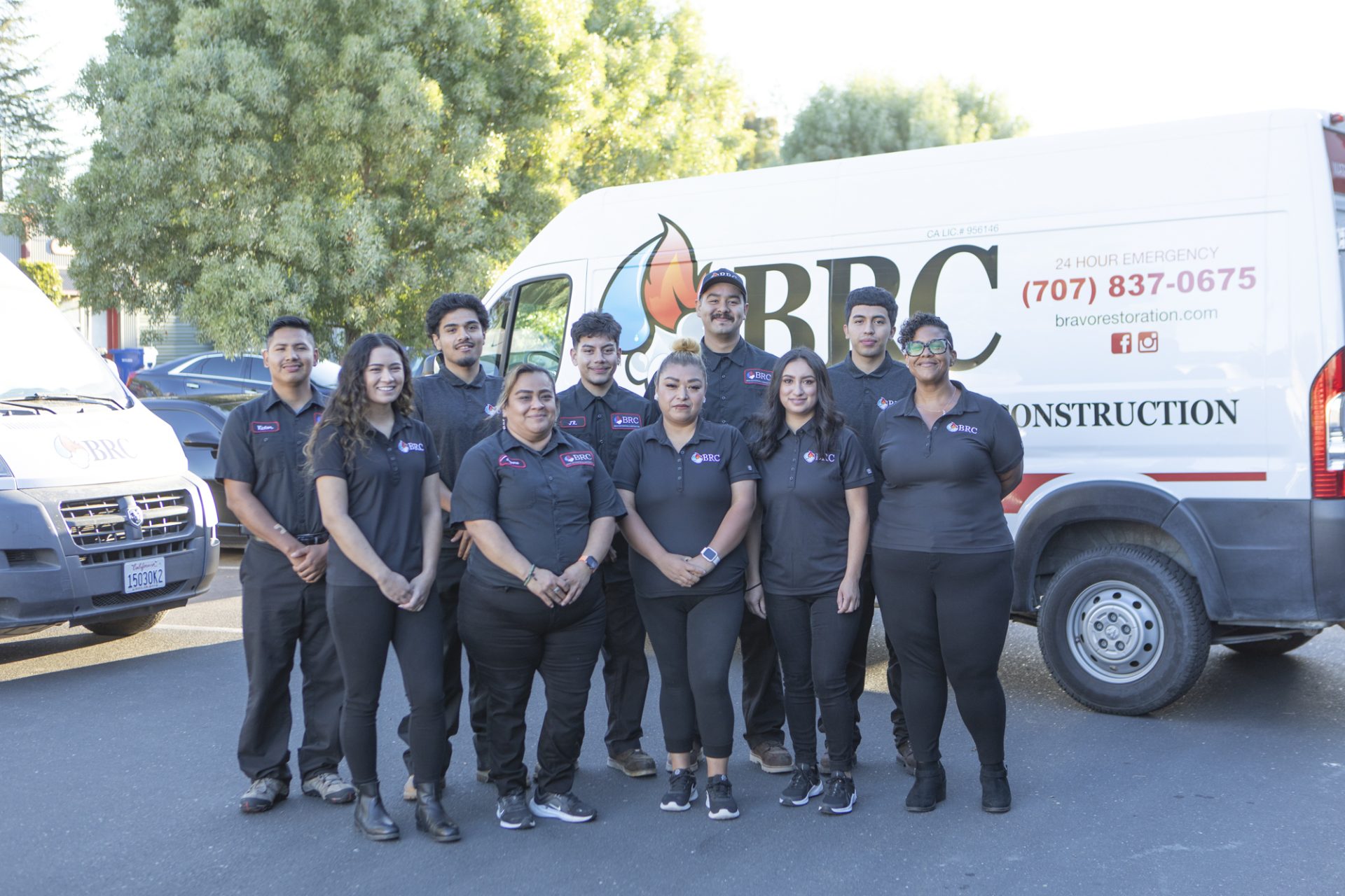 A group of people posing in front of a van equipped with fire damage remediation expertise.